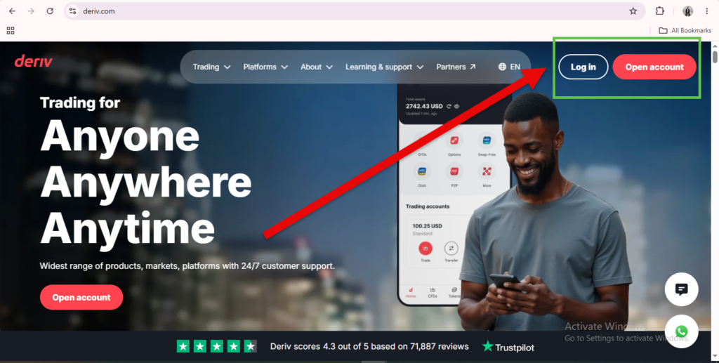 A man smiling at his phone on the Deriv homepage highlights how user-friendly the platform is. A red arrow points to the “Log in” and “Open account” buttons in the upper right corner, clearly illustrating the Deriv website layout and easy navigation.